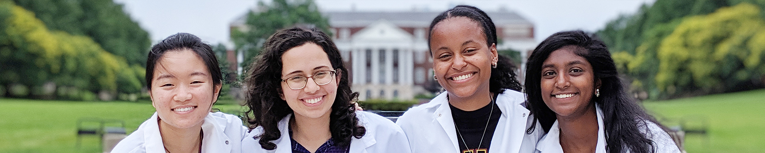 A group of young women in lab coats on McKeldin Mall